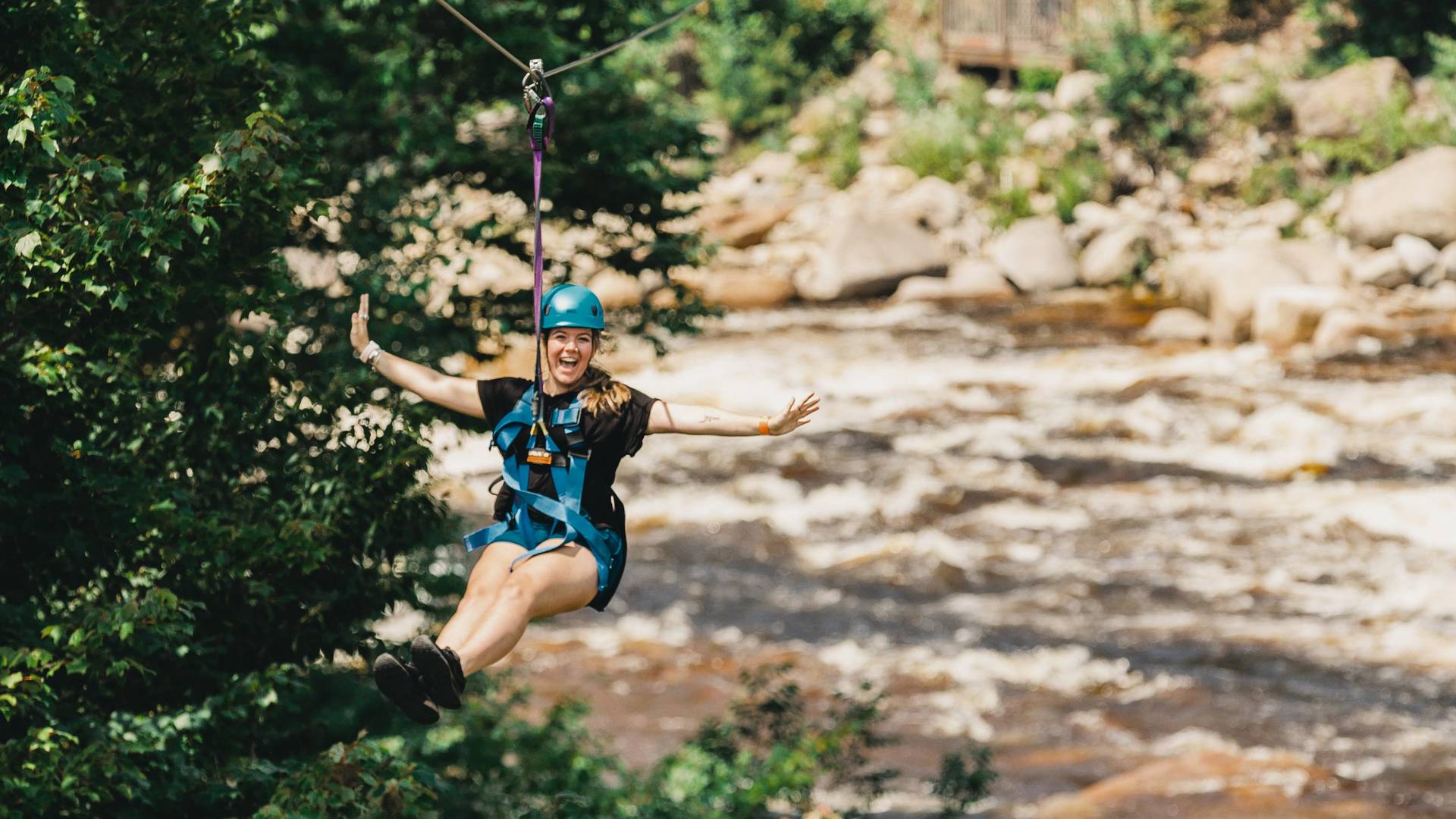 girl ziplining across the river