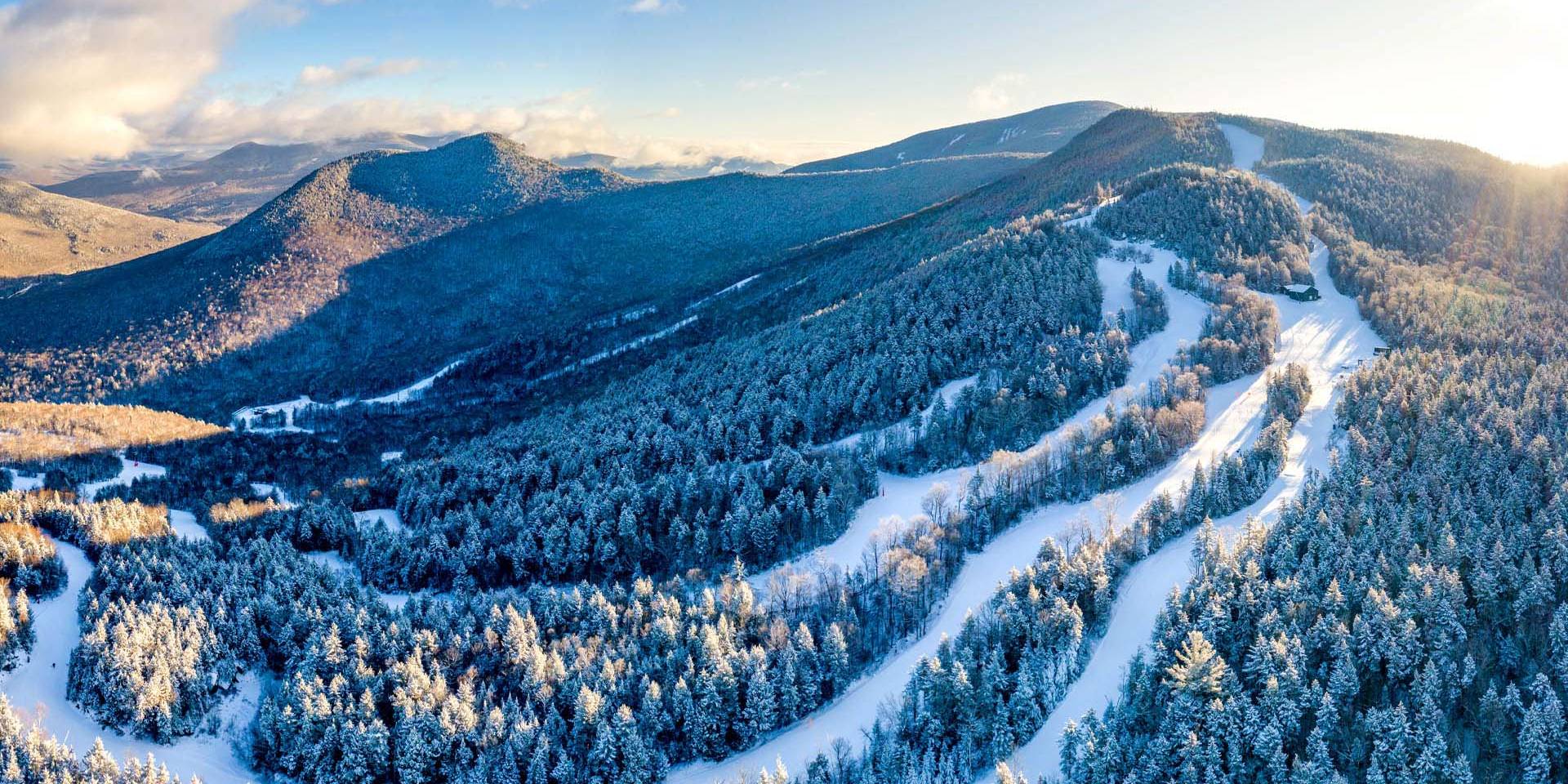 Aggressive skier in blue jacket skiing deep powder at Loon Mountain