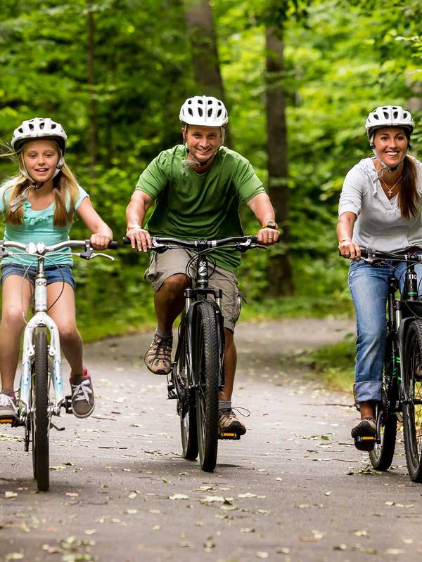 Family riding bikes on a paved bike path