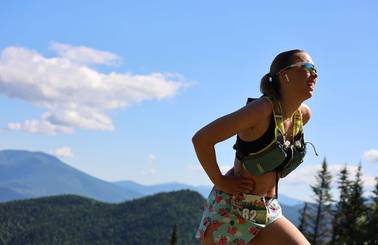 female runner wearing with mountains in background