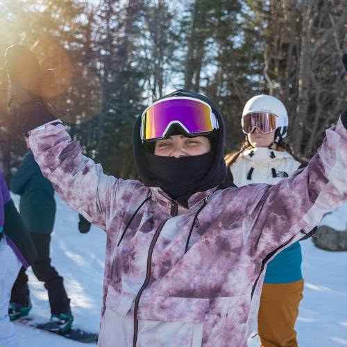 female snowboarder standing in a group