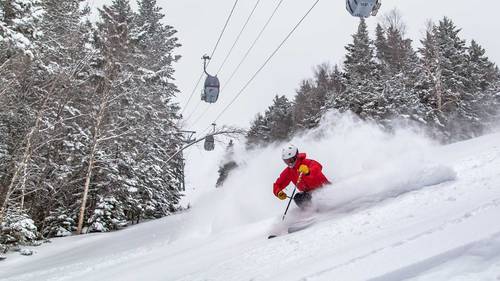 person powder skiing on ski trail at Loon Mountain
