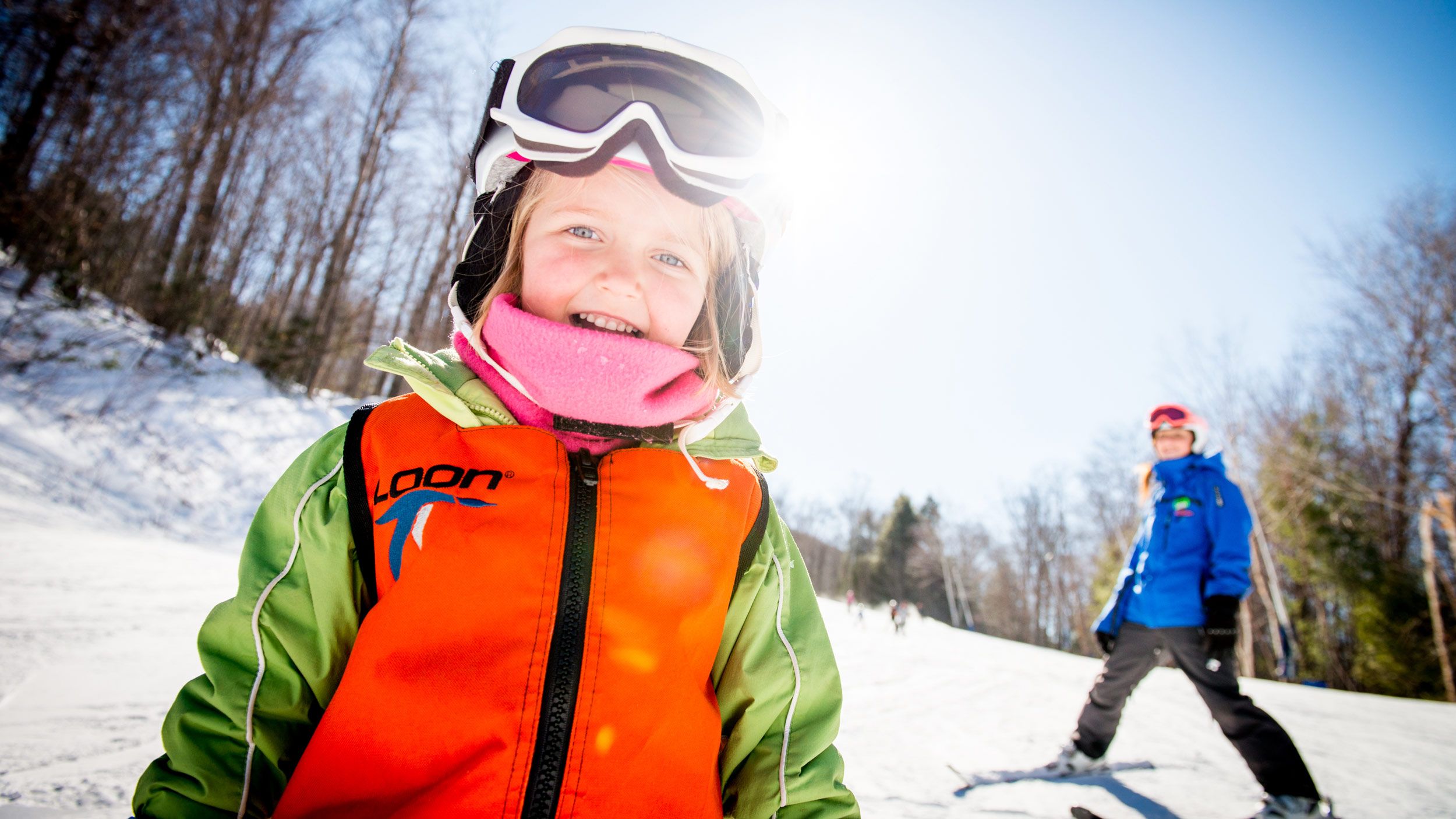 child with coach learning to ski