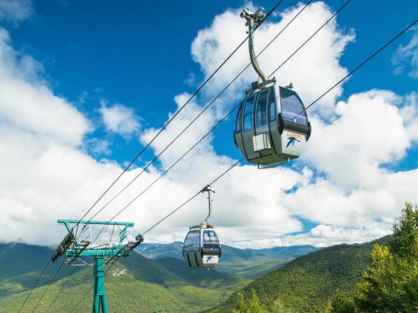 Summer Gondola Skyride with White Mountains and trees in the background.