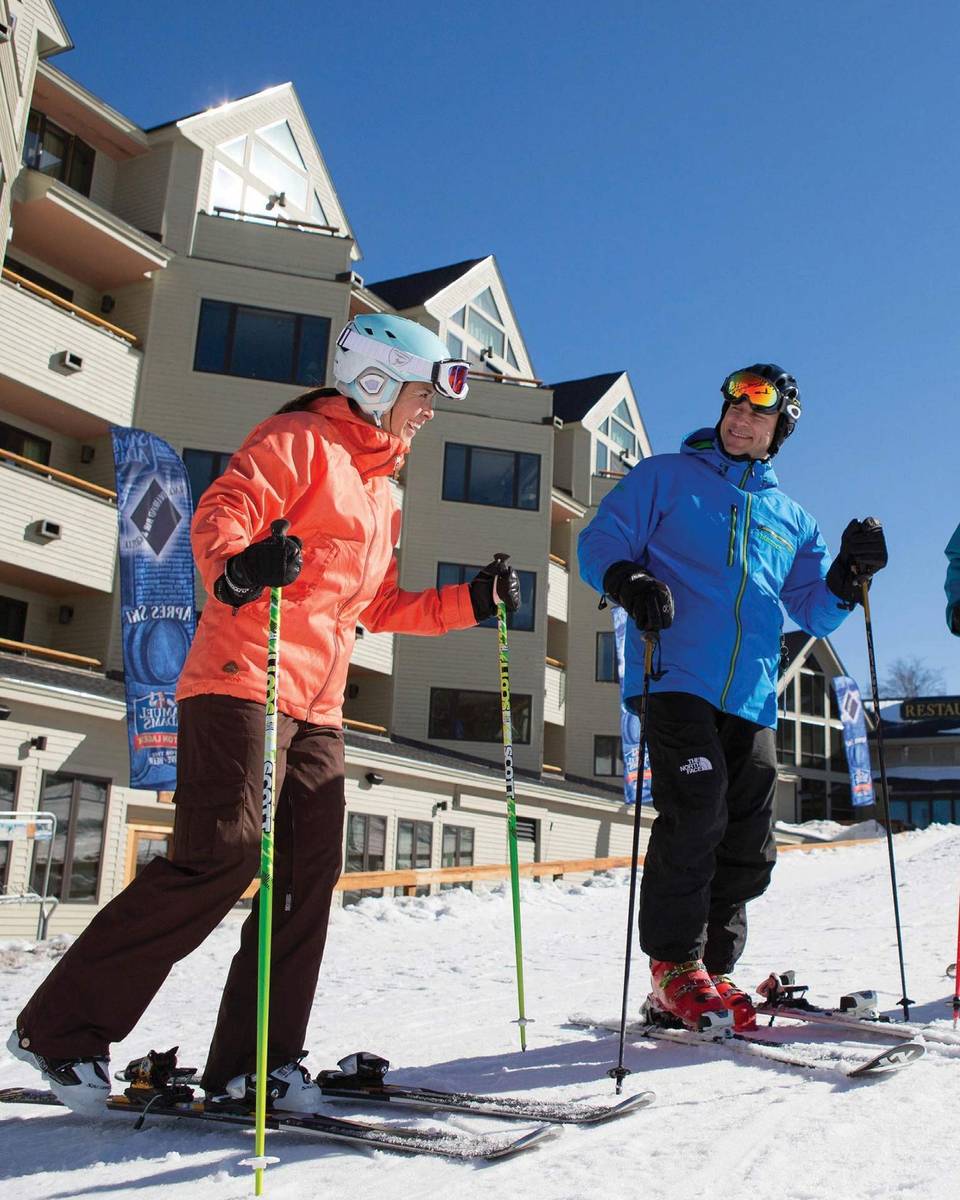 Skiers standing outside the Mountain Club on Loon slopeside hotel