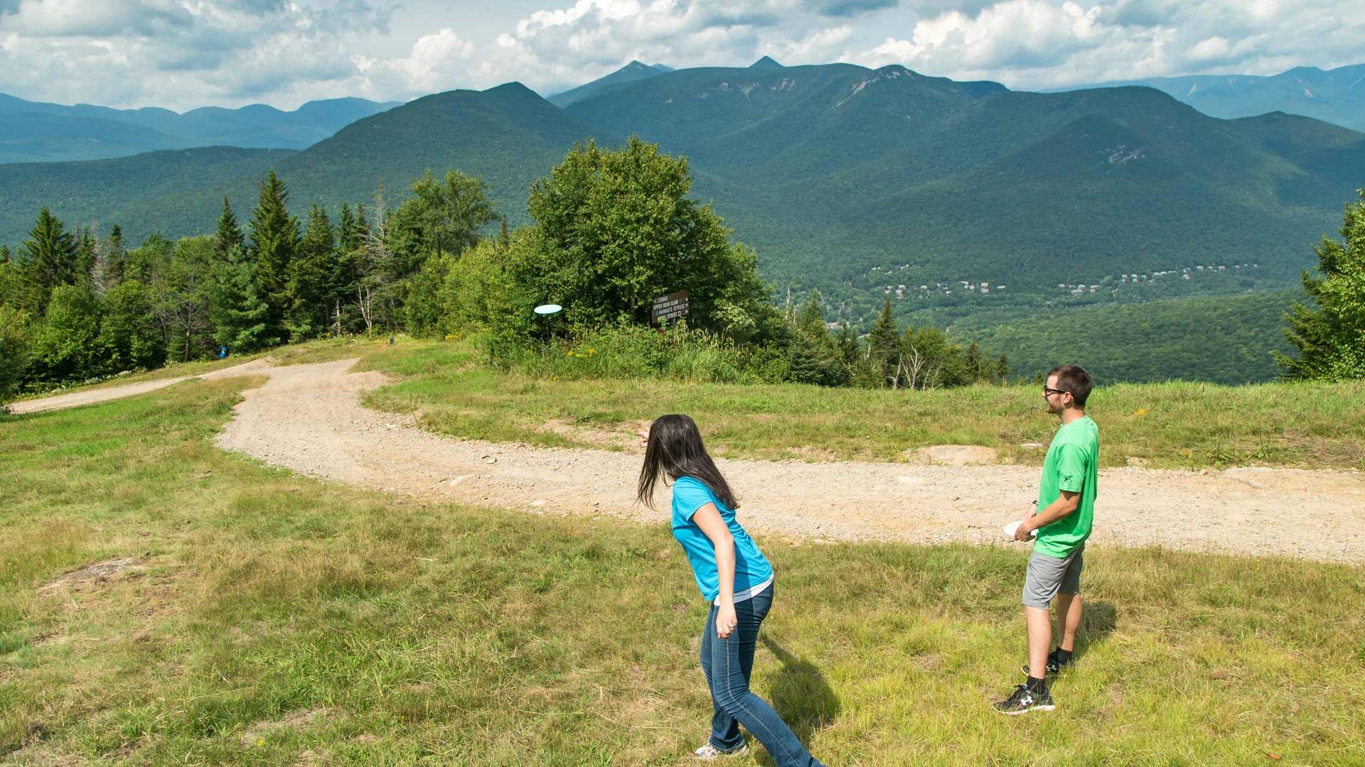 People playing disc golf at Loon with mountain background