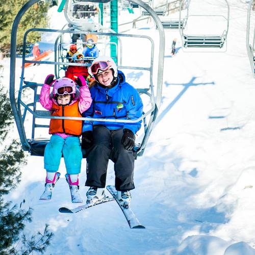skier with a coach on a chairlift