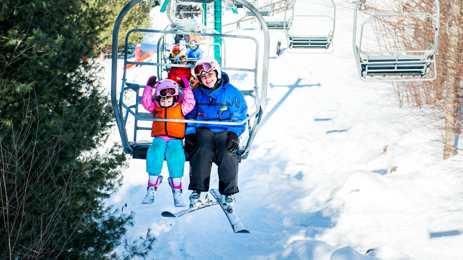 Little girl and coach riding chairlift