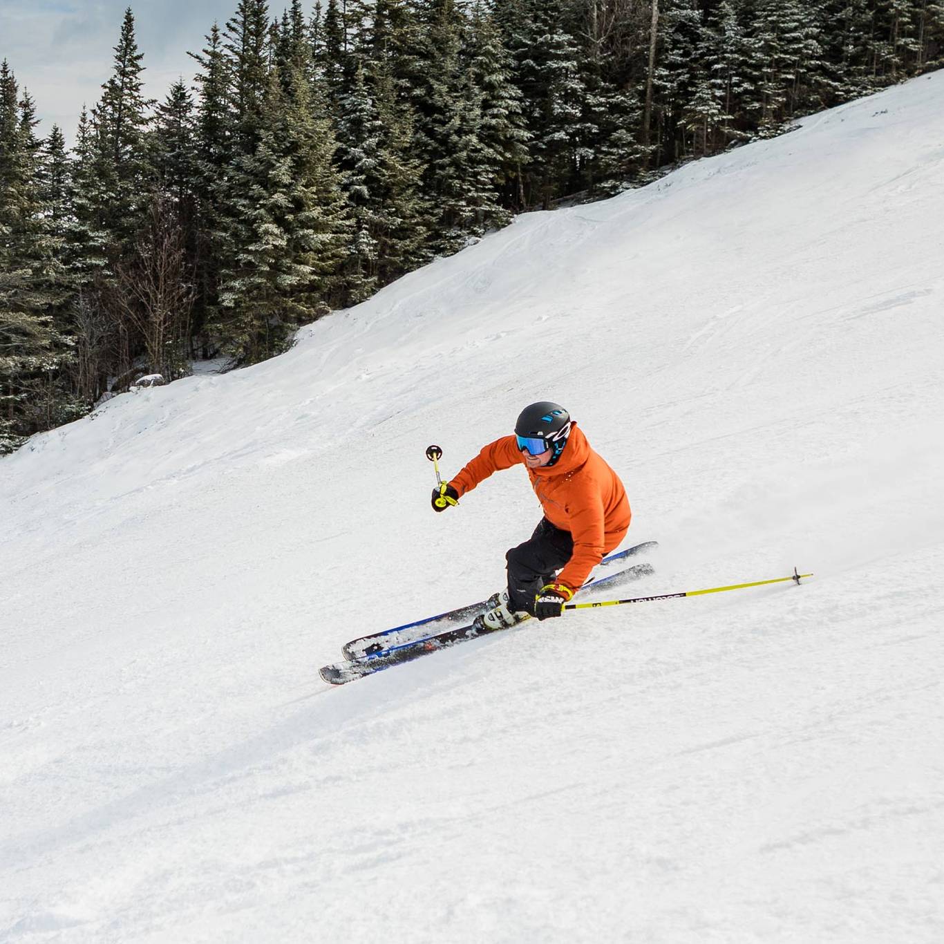 skier in orange jacket skiing down Upper Walking Boss trail at Loon Mountain Resort