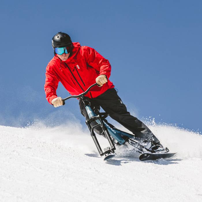 Man carving a turn riding a Sno-Go