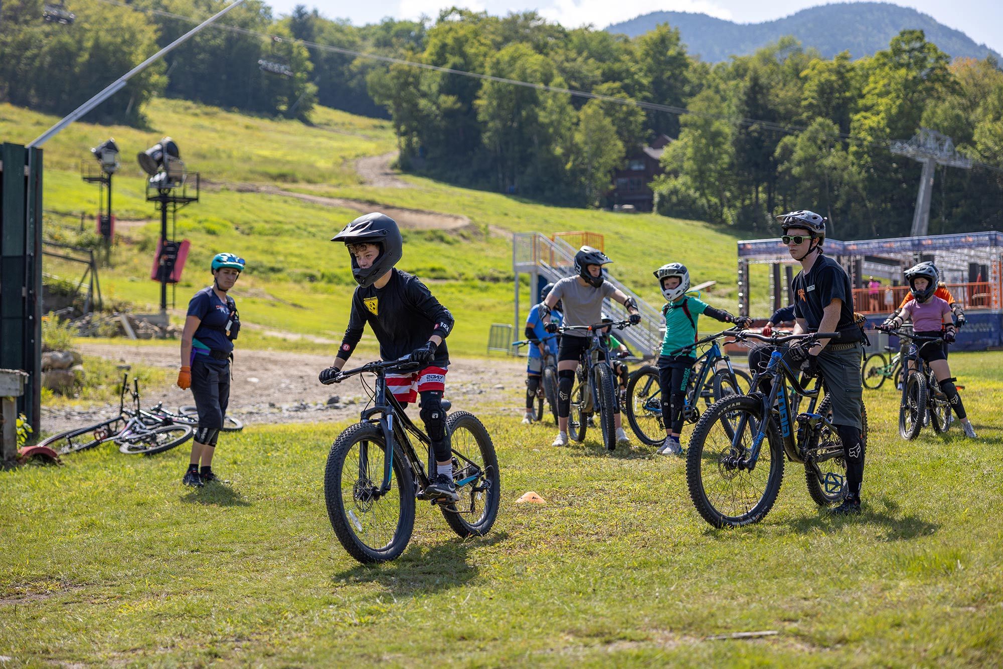 young boy riding while instructor coaches him