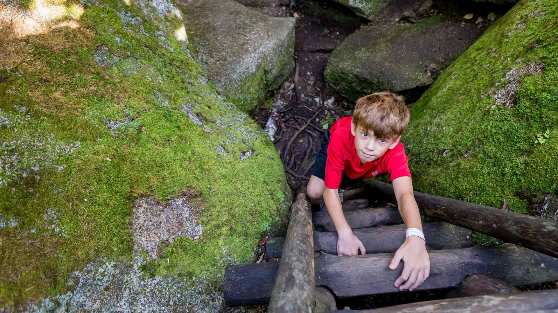 boy climbing a wooden ladder in the glacial caves