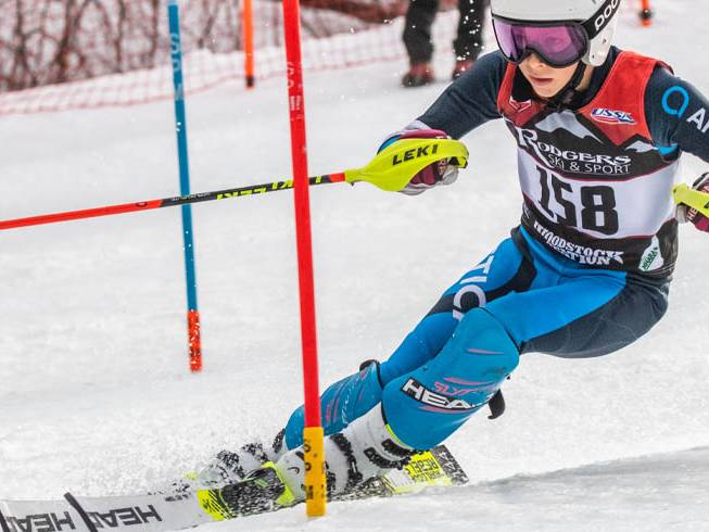 young boy racing through a giant slalom gate