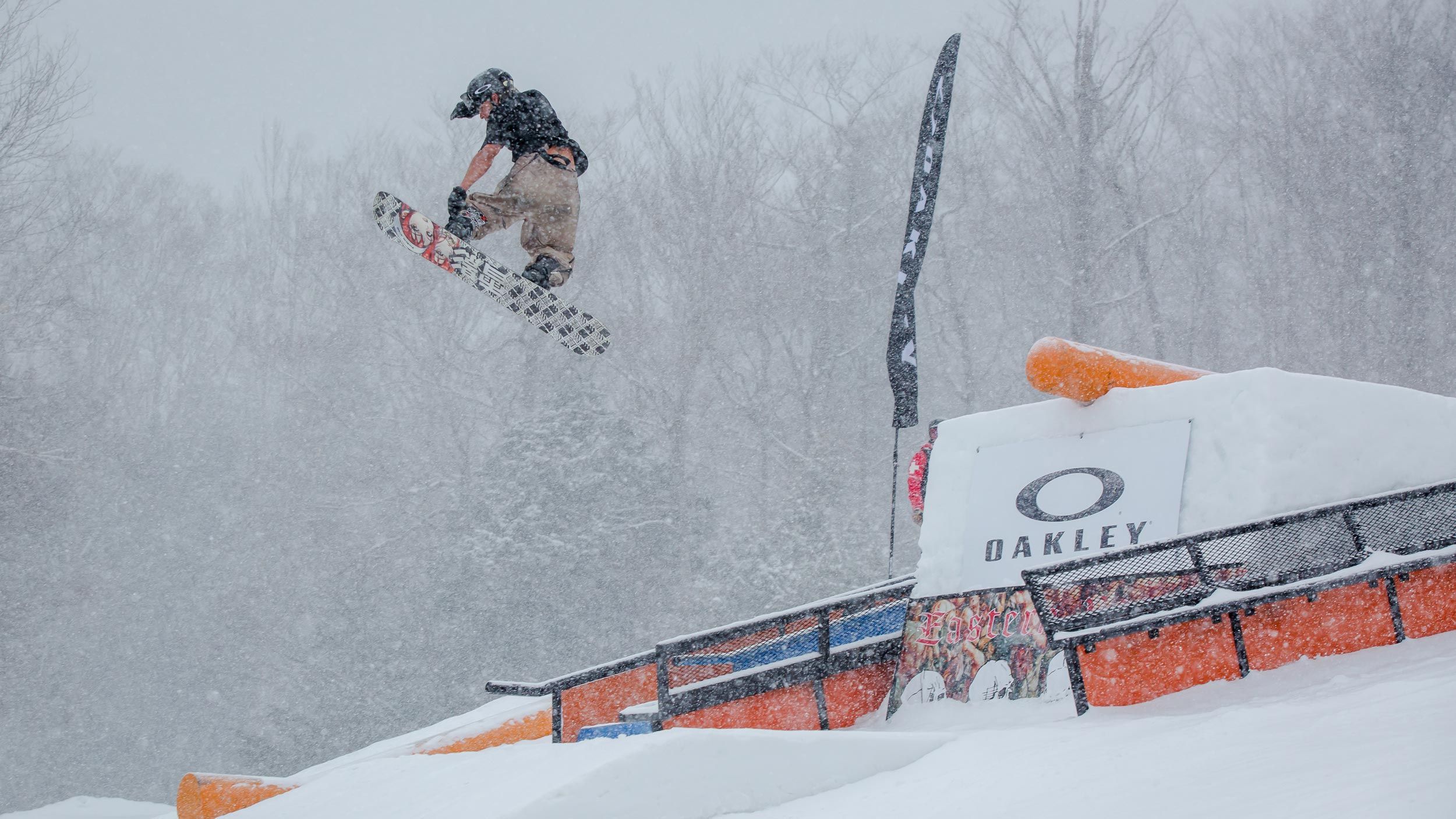 male snowboarder doing trick off of rail