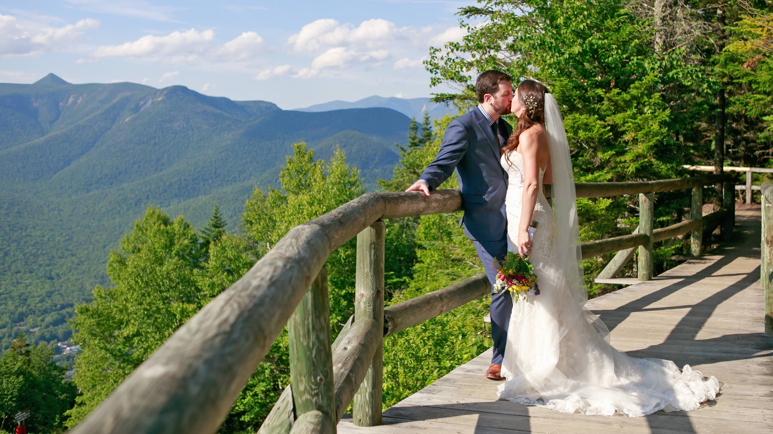 Wedding couple taking mountaintop photos