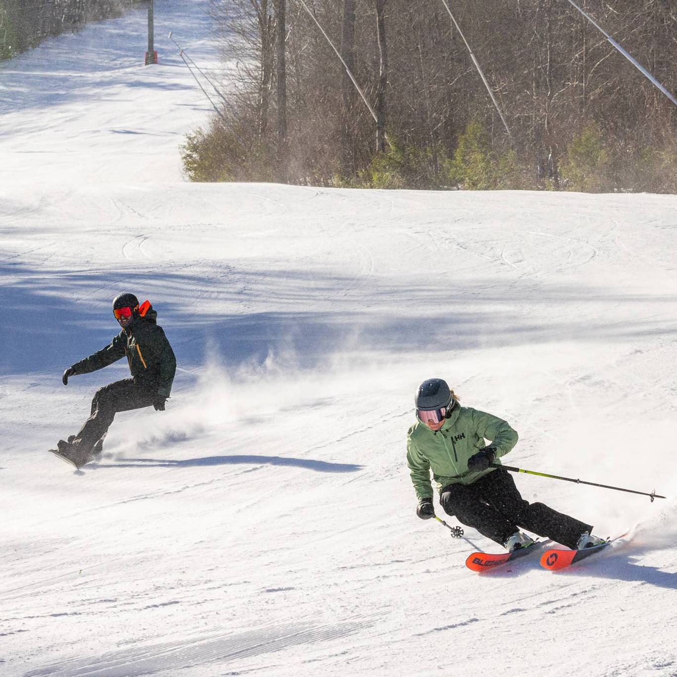 Skiers and snowboarder carving a trail at Loon Mountain