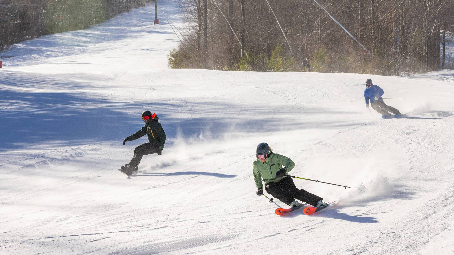 group of skiers and snowboarders enjoying a trail at Loon Mountain
