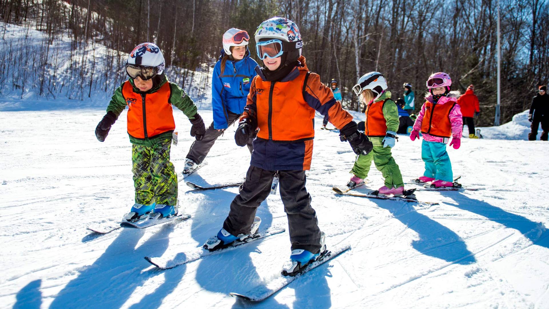 group of kids learning with a ski instructor
