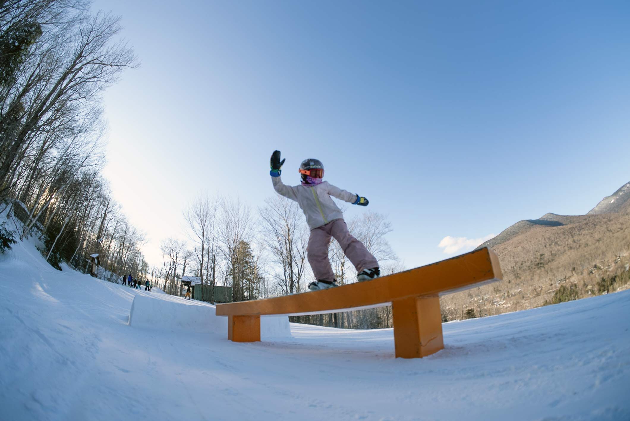 Young snowboarder riding a rail