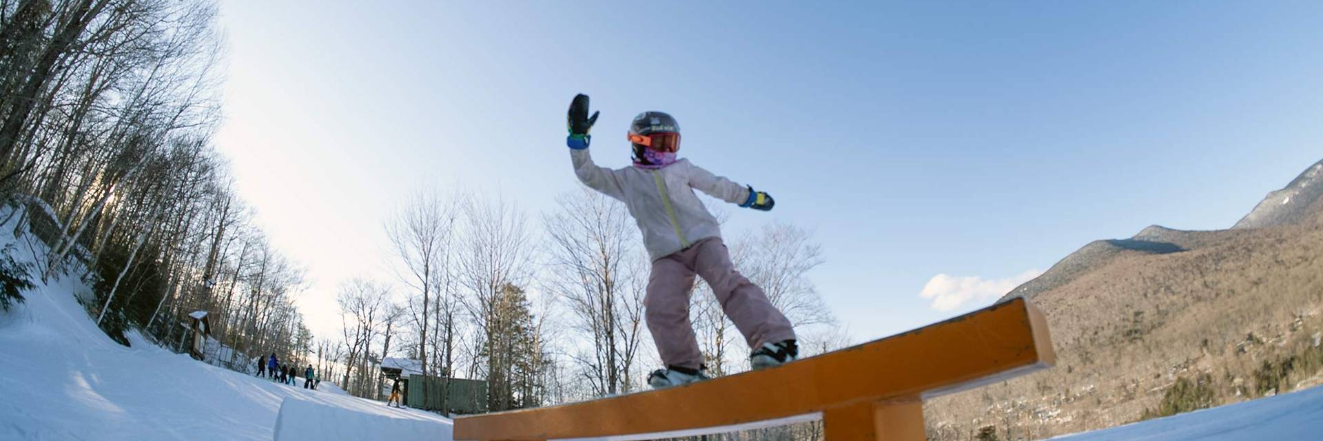 Young snowboarder riding a rail
