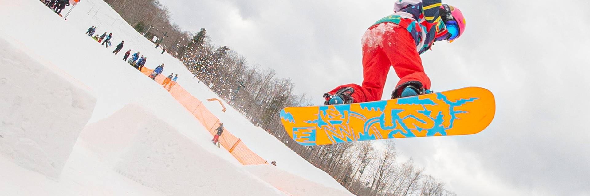 young snowboarder going off jump