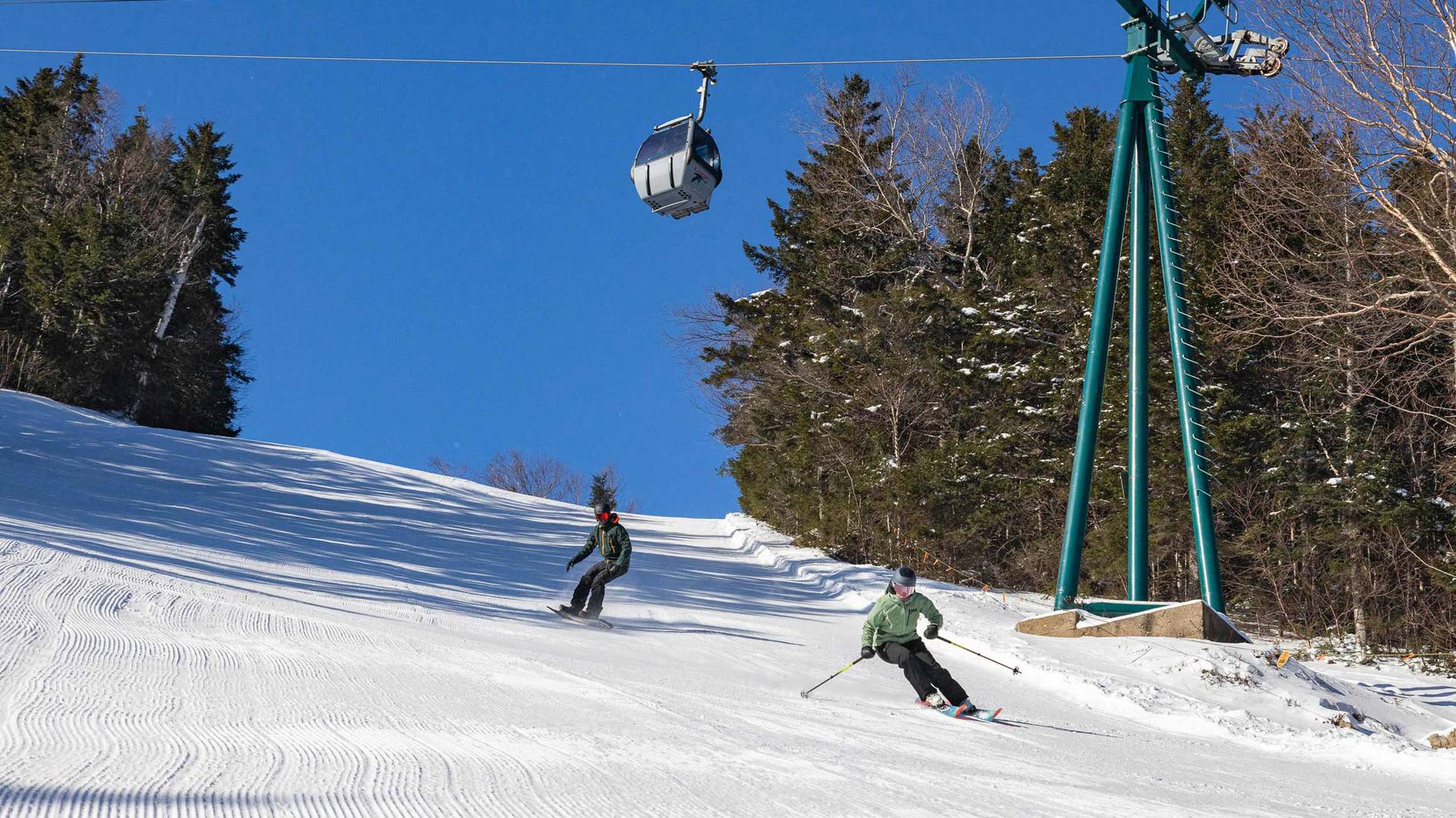 Skier and snowboarder on Angel Street at Loon Mountain