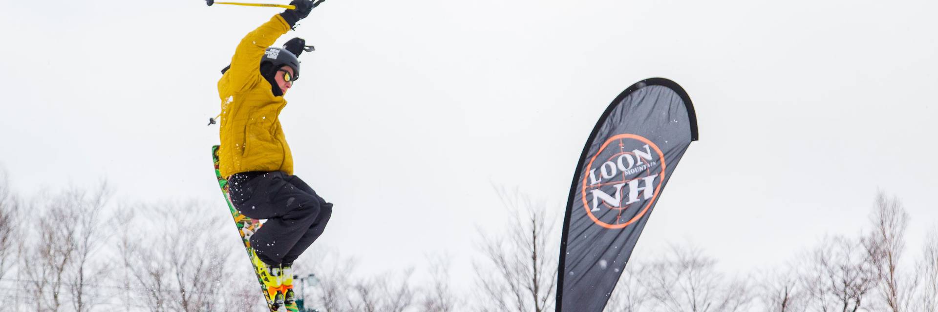 young teen freeskier going off a park element