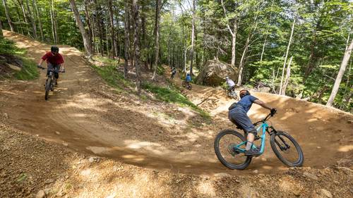 Group of riders cornering a berm in Loon Bike Park