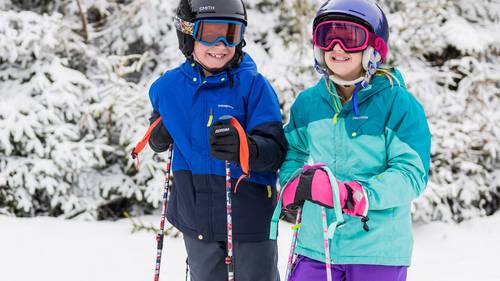 Two young smiling kids enjoying the snowy trails at Loon Mountain