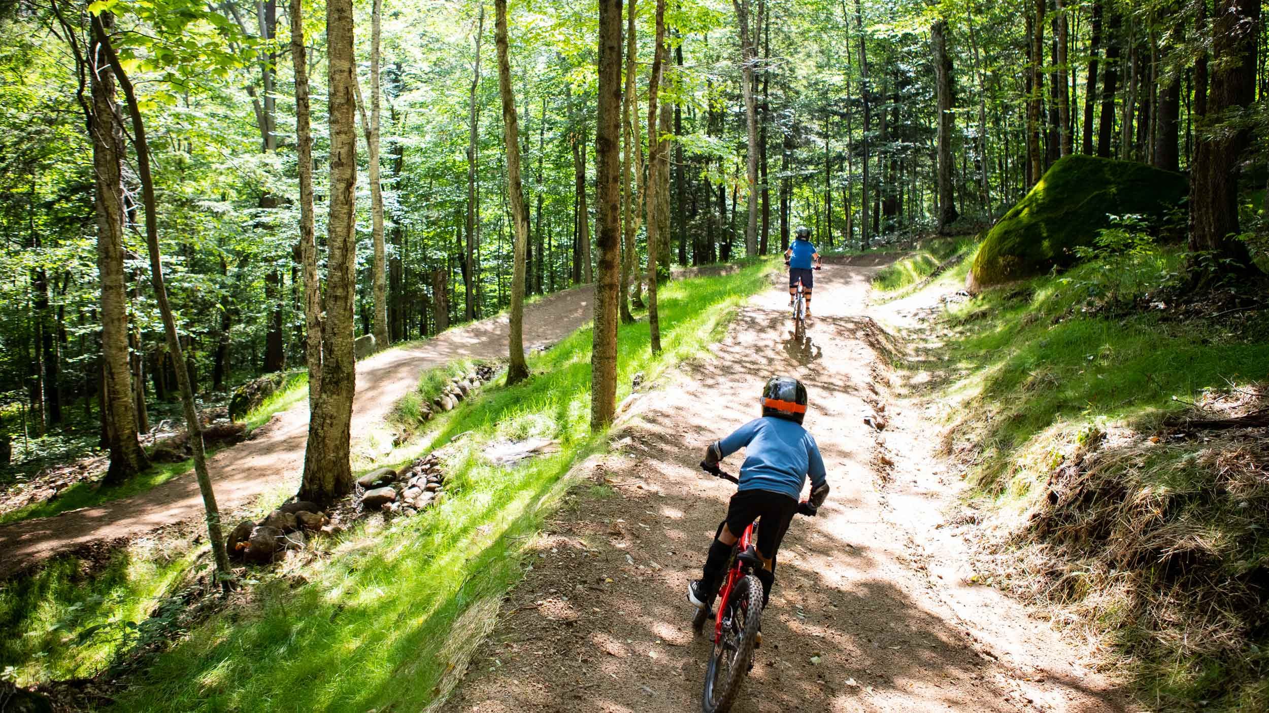 Two kids riding downhill mountain bike trail at Loon Bike Park