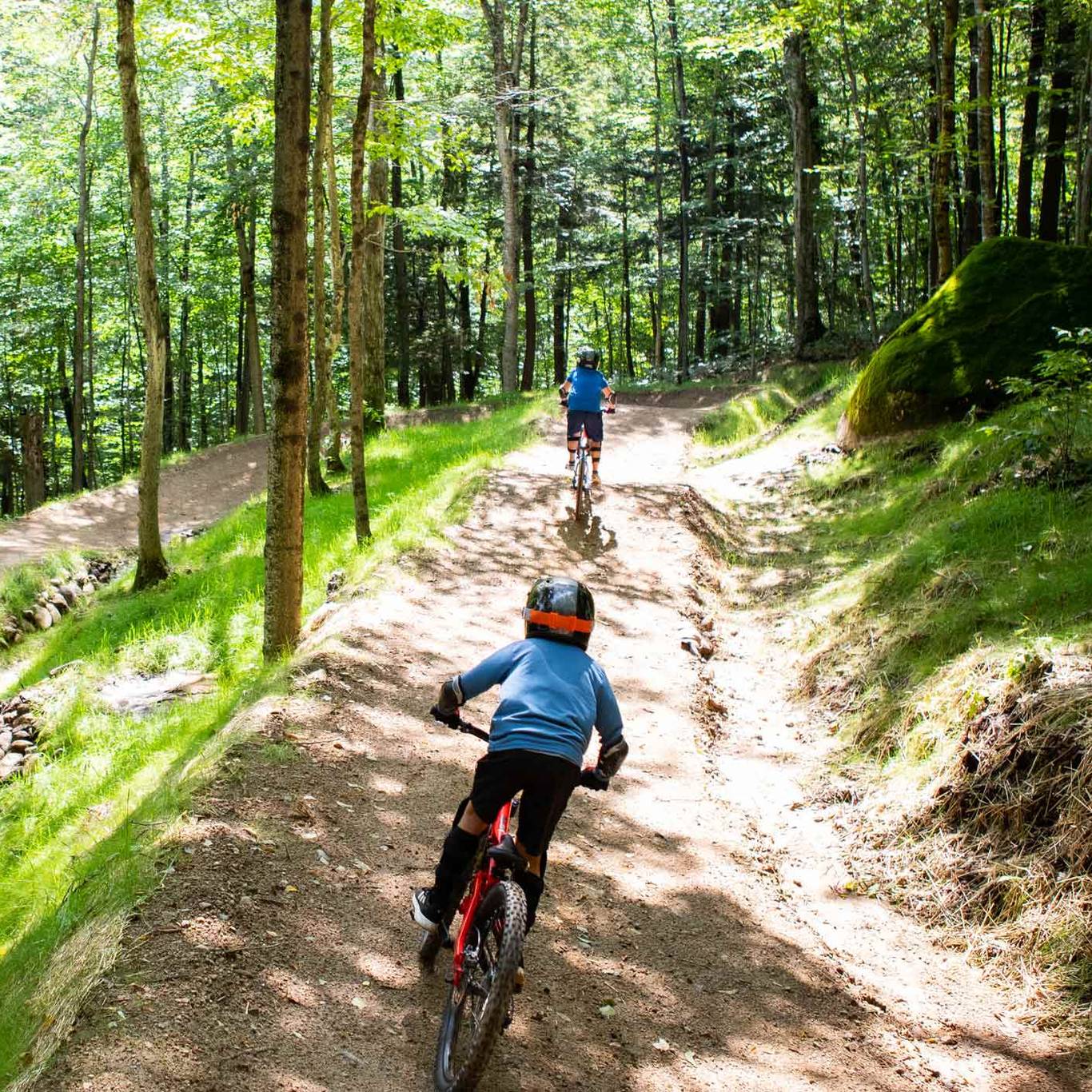 Two kids riding downhill mountain bike trail at Loon Bike Park