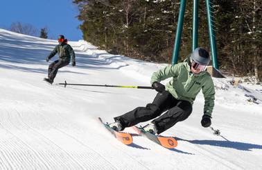 skier and snowboarder on groomed trail at Loon Mountain