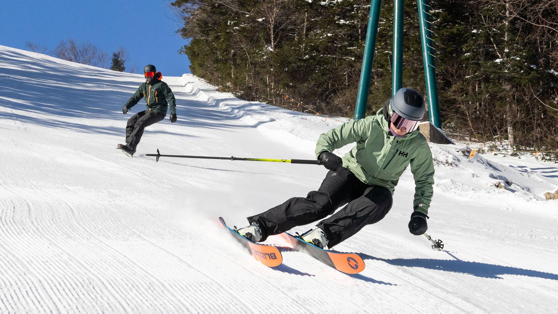 Skier and snowboarder on groomed trail at Loon Mountain