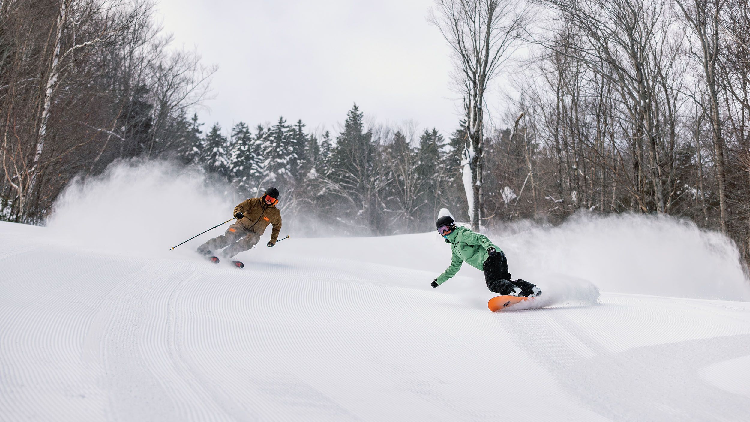 skier and snowboarder on groomed trail at Loon Mountain