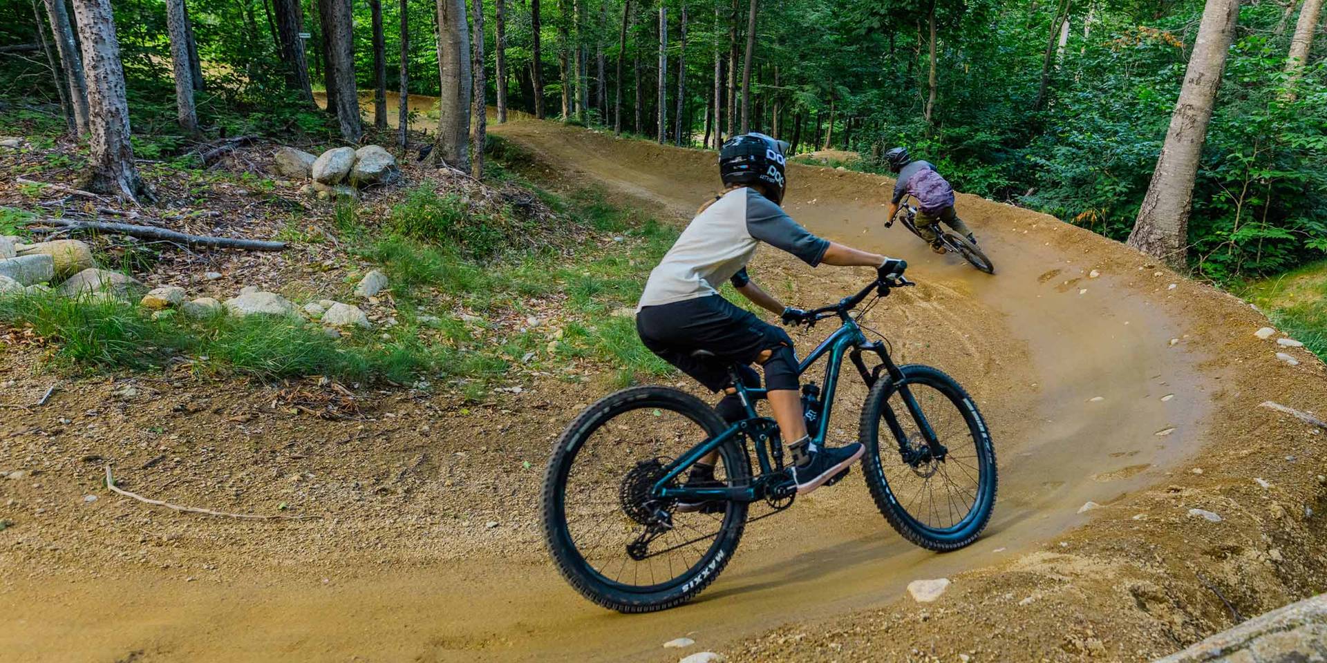 Man and woman riding an aggressive berm in Loon Bike Park