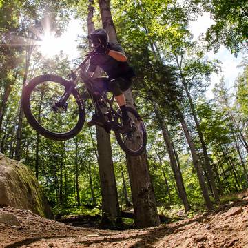 Downhill mountain bike rider jumping off a rock feature