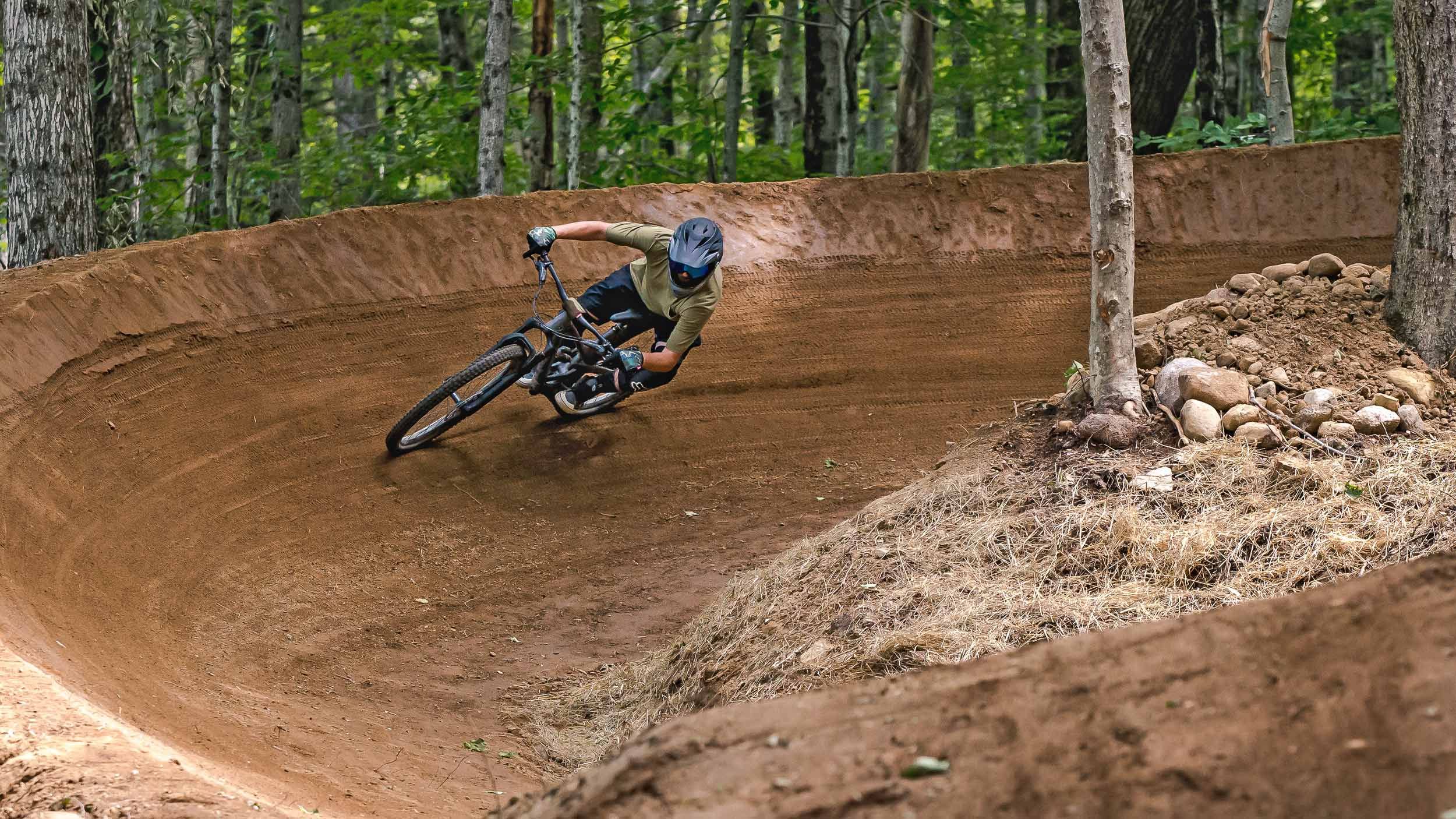 downhill mountain biker cornering a berm in Loon Bike Park