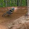 downhill mountain biker cornering a berm in Loon Bike Park