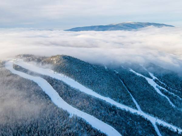 Drone image of peak in the winter with clouds