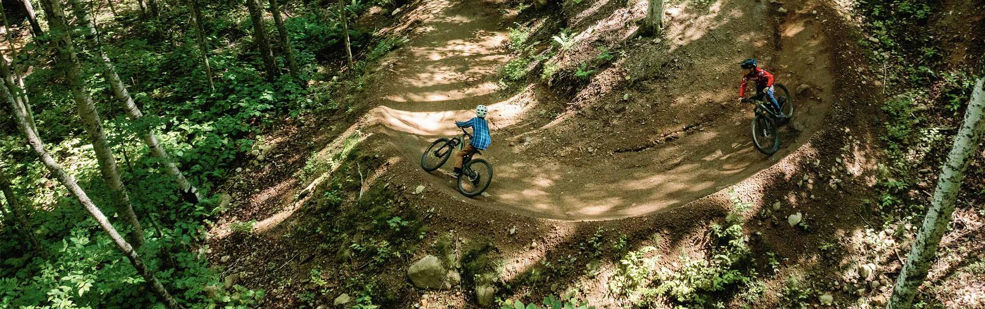 drone image of 2 bikers on a berm