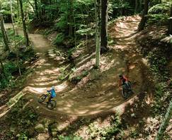 Downhill mountain bike rider jumping off a rock feature