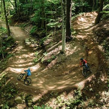 Downhill mountain bike rider jumping off a rock feature