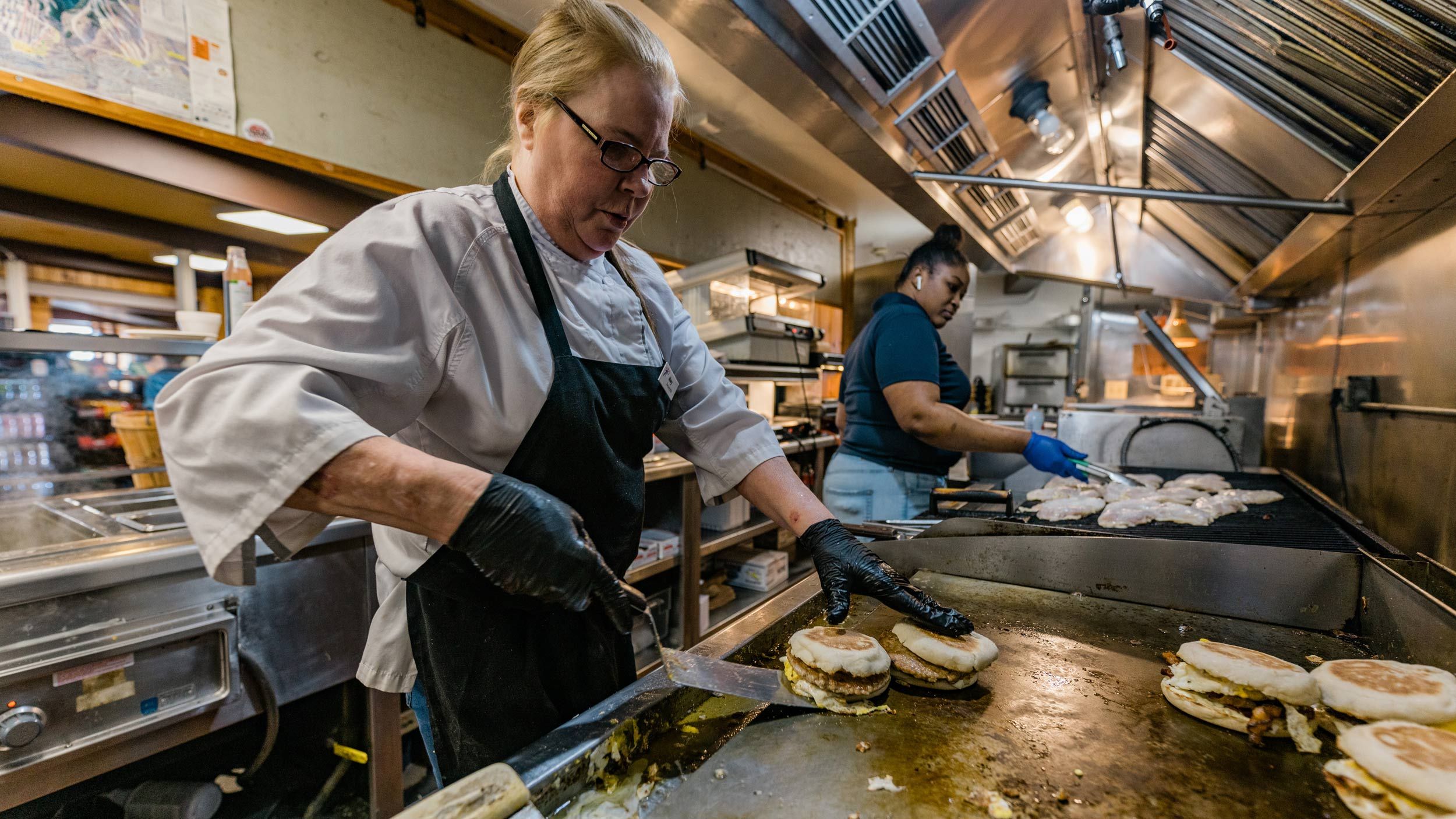 cook making breakfast sandwiches 
