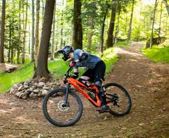 aggressive downhill mountain biker riding a berm in Loon Bike Park