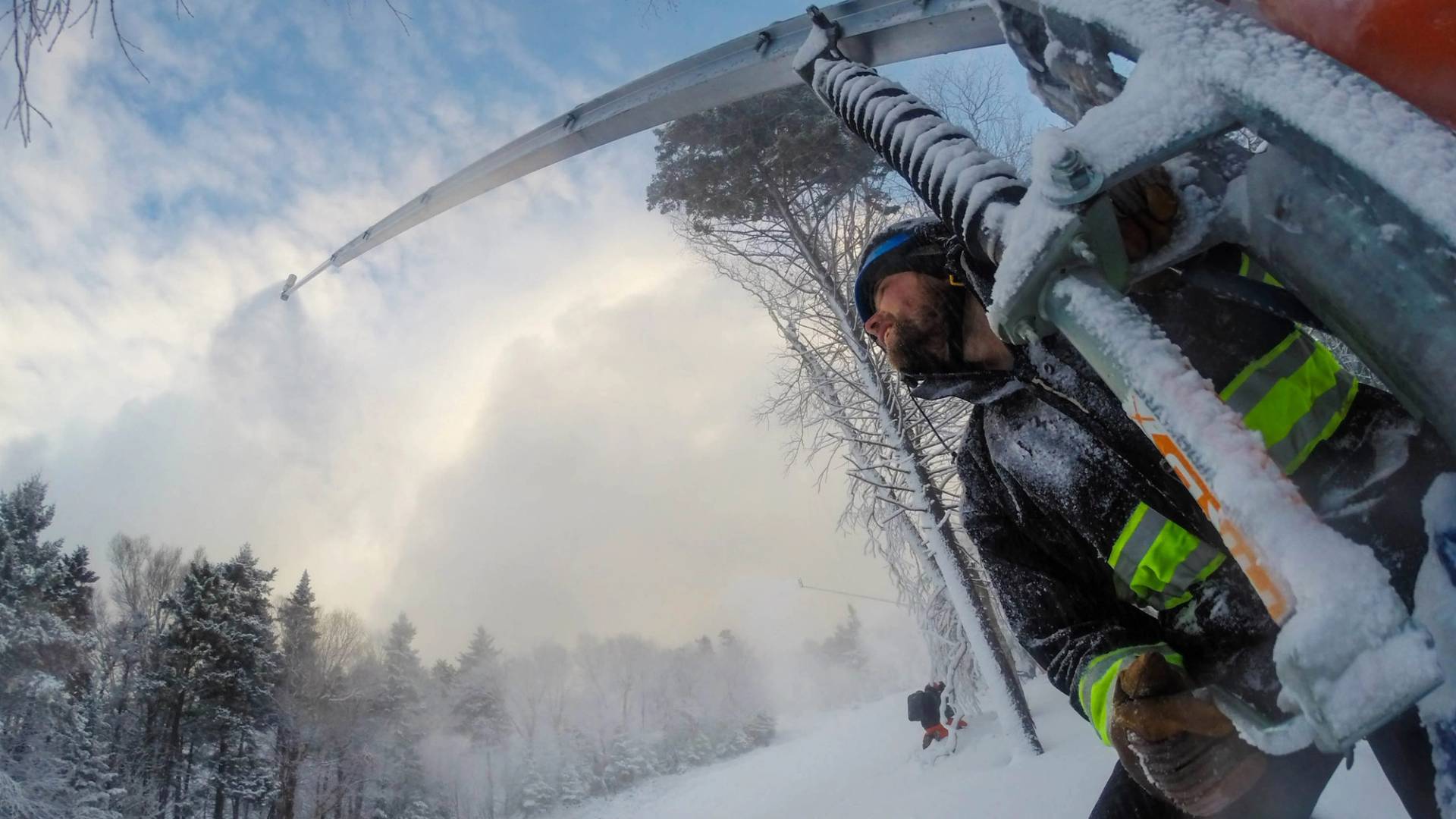 Man operating a snowmaker in winter