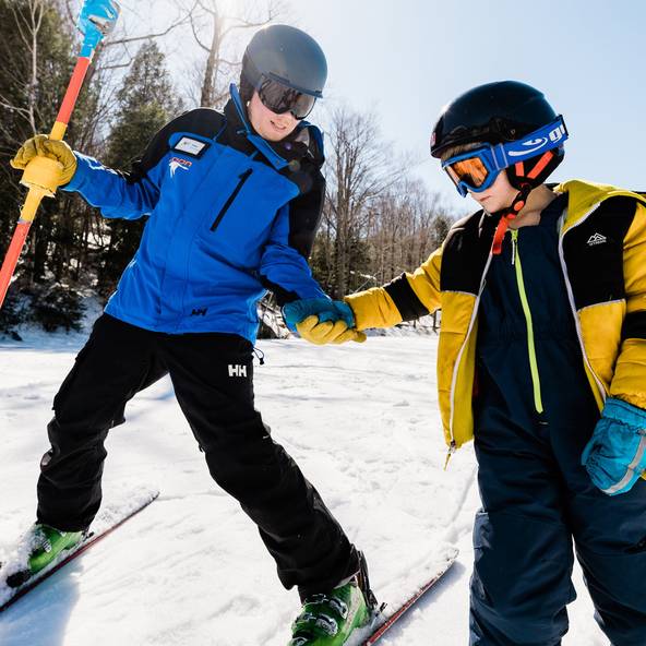 instructor helping a child in a ski lesson at Loon Mountain