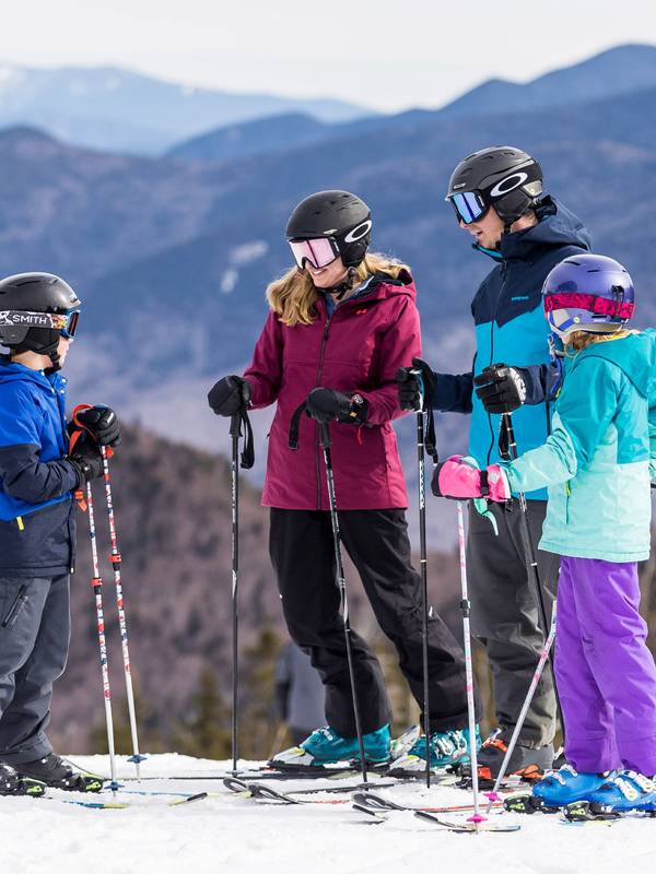 Ski family standing atop Loon Peak summit in winter