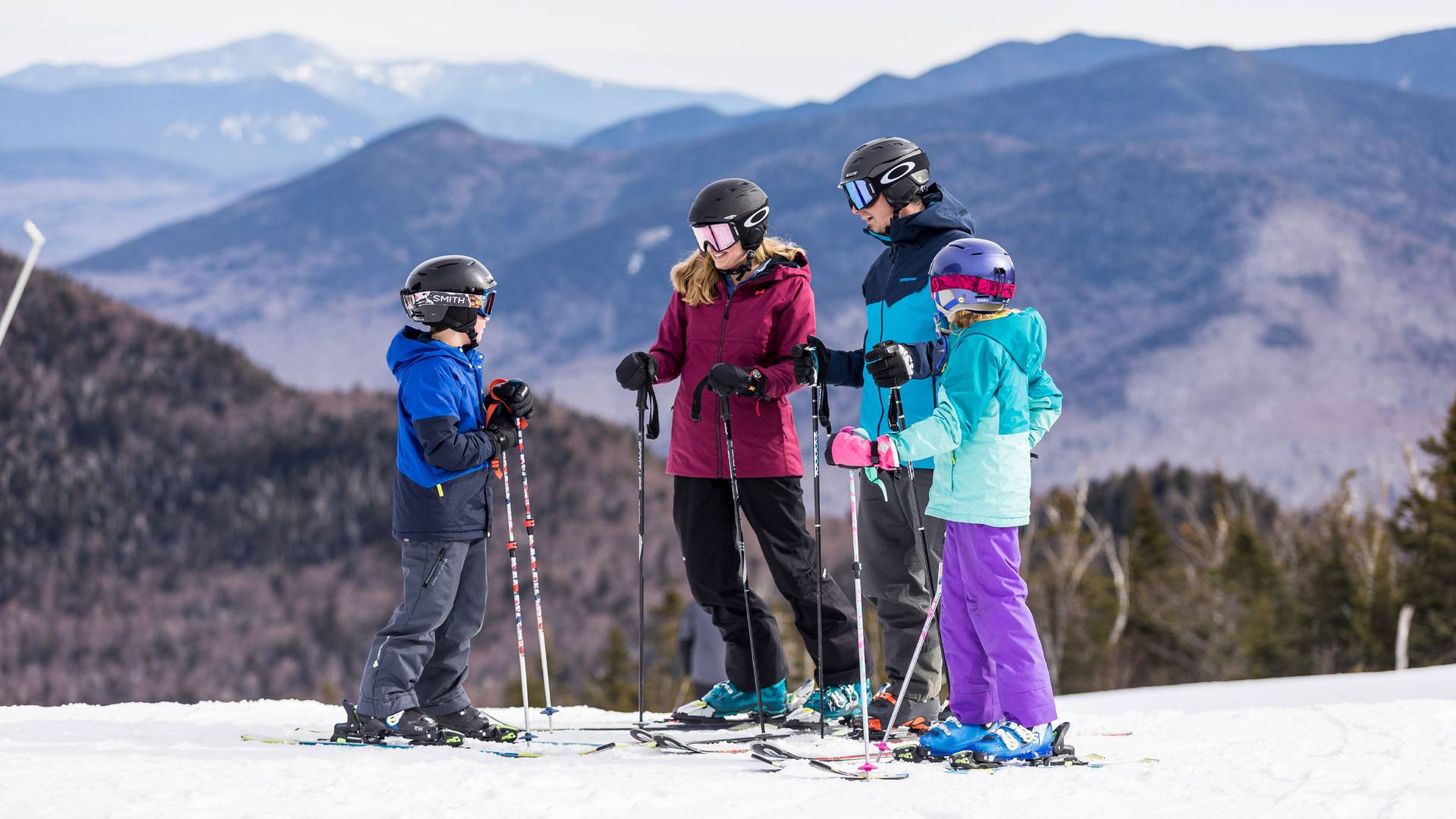 family of skiers standing at the summit of Loon Mountain