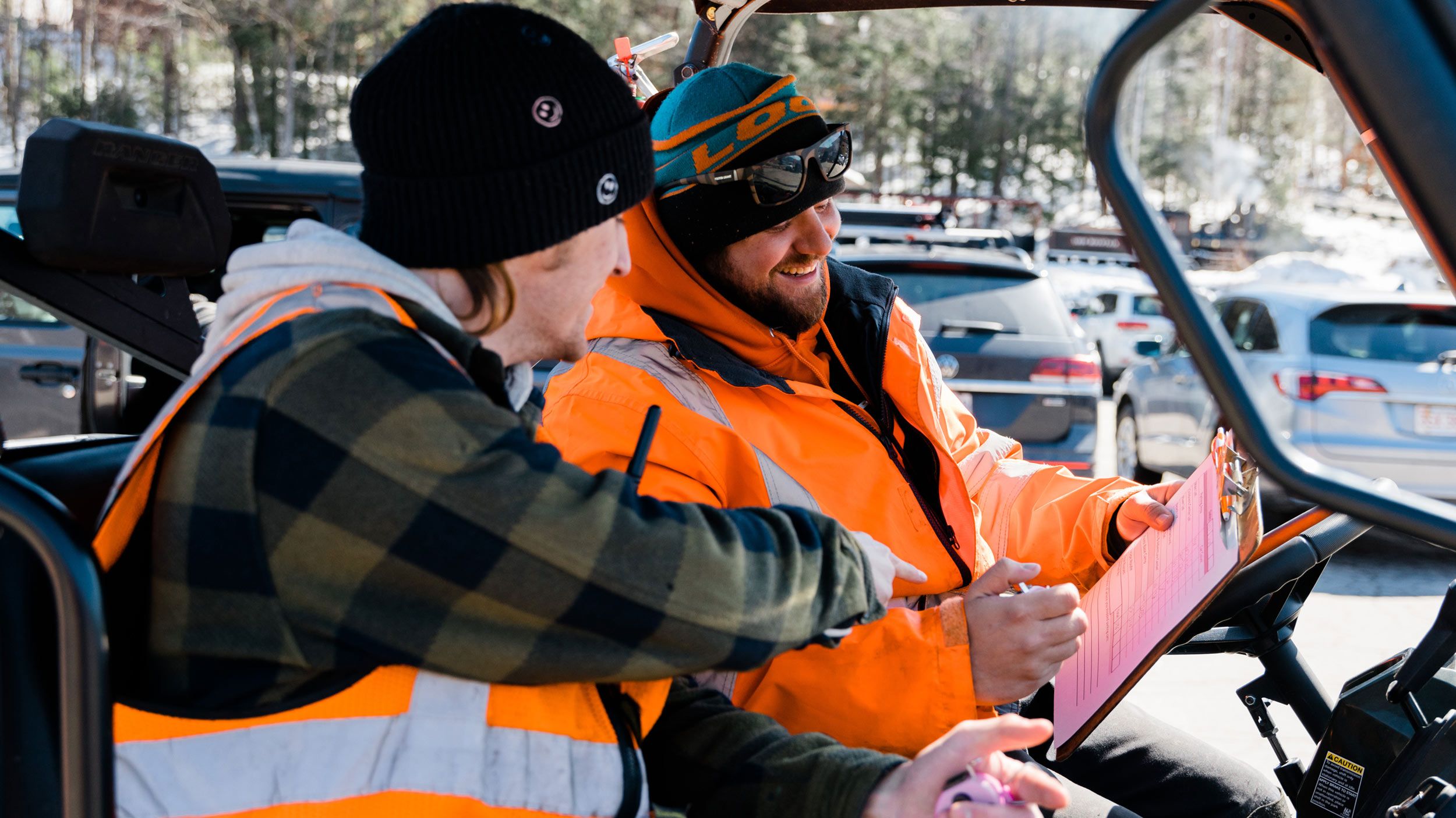 Two parking attendants looking at a log sheet