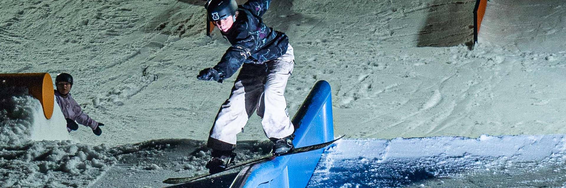 Snowboarder riding a rail at Cease and Desist